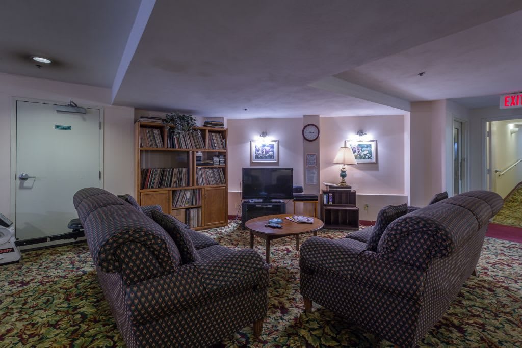A cozy living room with sofas, a television, and a well-stocked bookshelf.