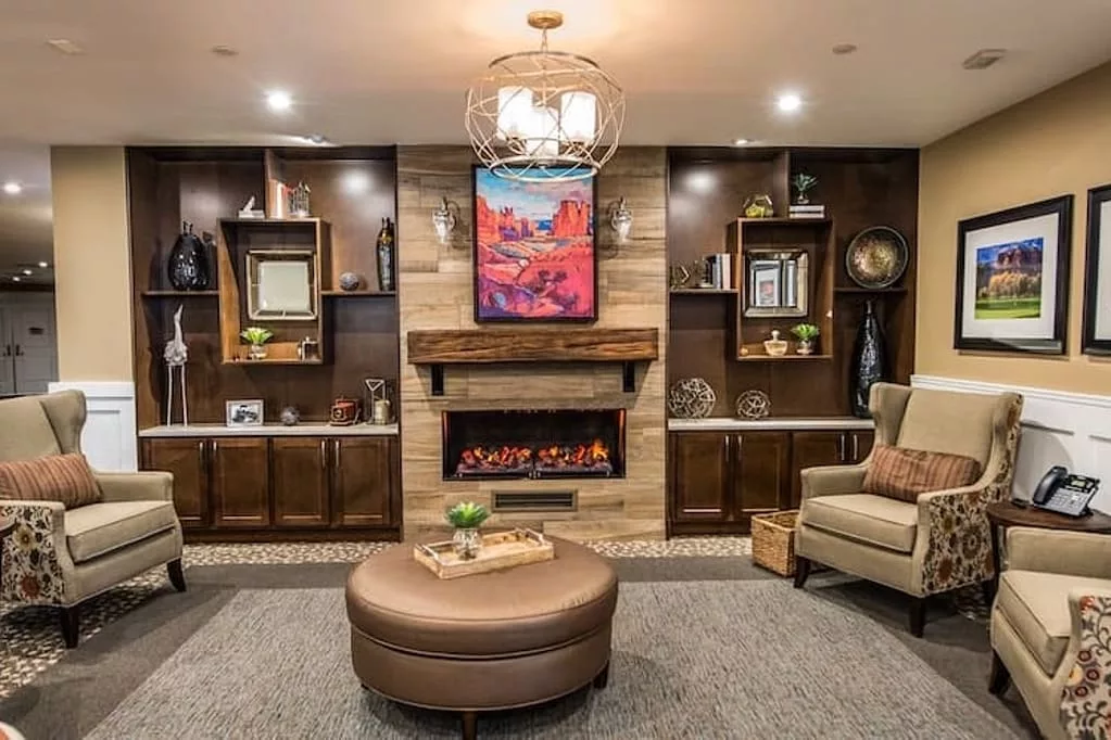 A modern living room featuring a central fireplace, surrounded by built-in shelving and stylish decor.