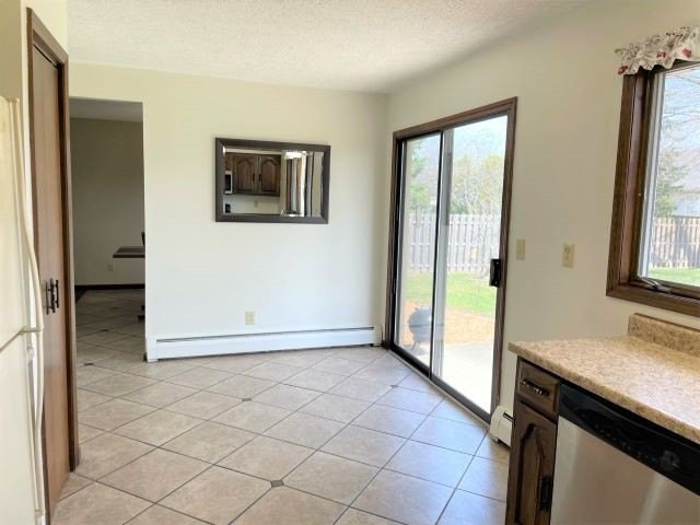 A bright living room with a sliding glass door and tiled flooring.