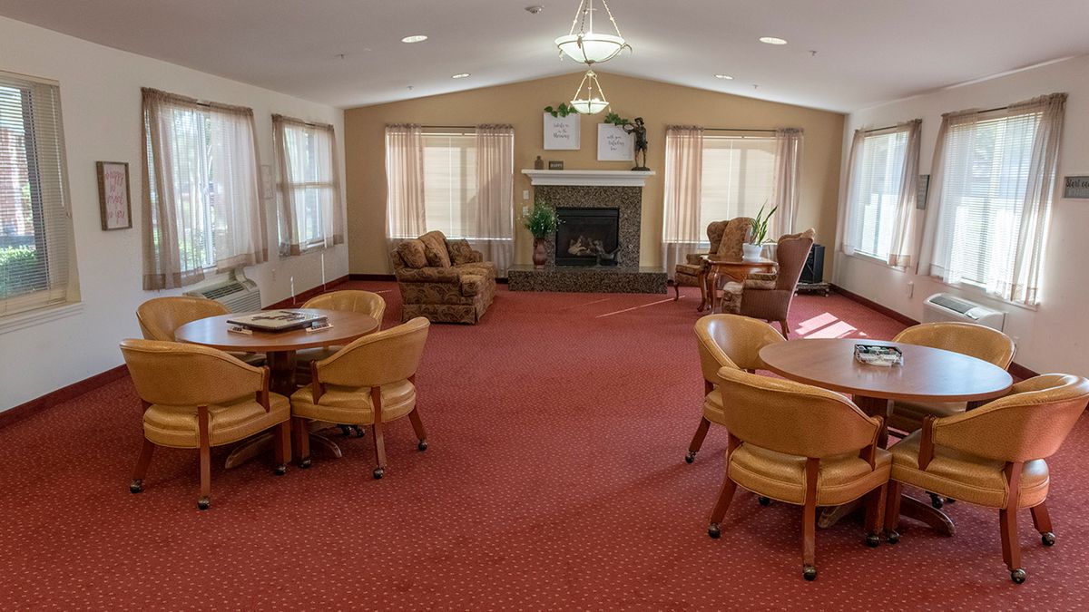A cozy living room with comfortable seating, tables, and a fireplace.