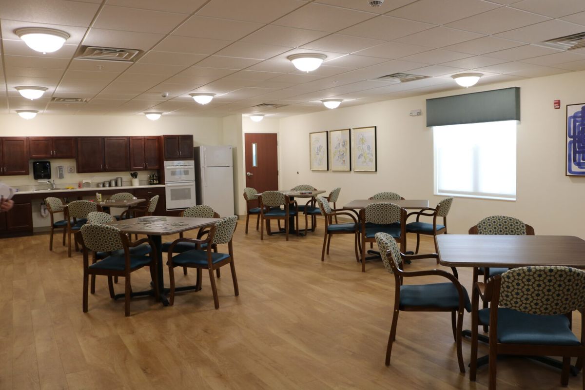 A clean and well-lit dining area with multiple tables and chairs.