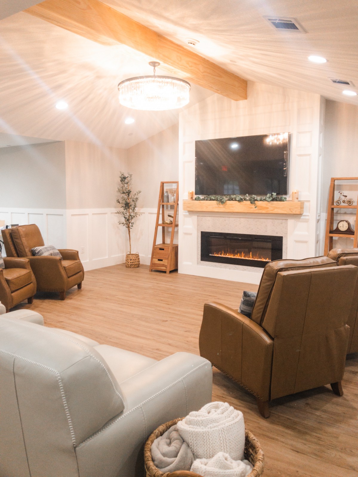 A modern and cozy living room with comfortable seating, a fireplace, and a large television.