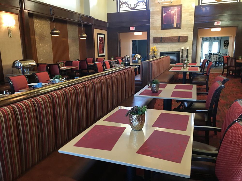 A cozy restaurant interior with neatly arranged tables and chairs, featuring red placemats and tasteful decor.