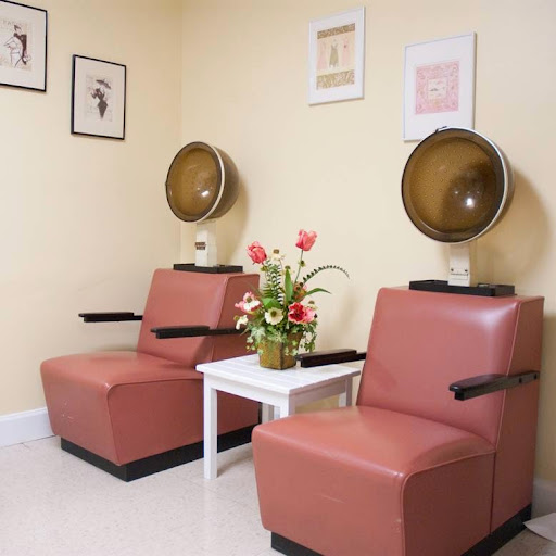 A cozy waiting area in a hair salon, featuring vintage-style chairs and decorative elements.