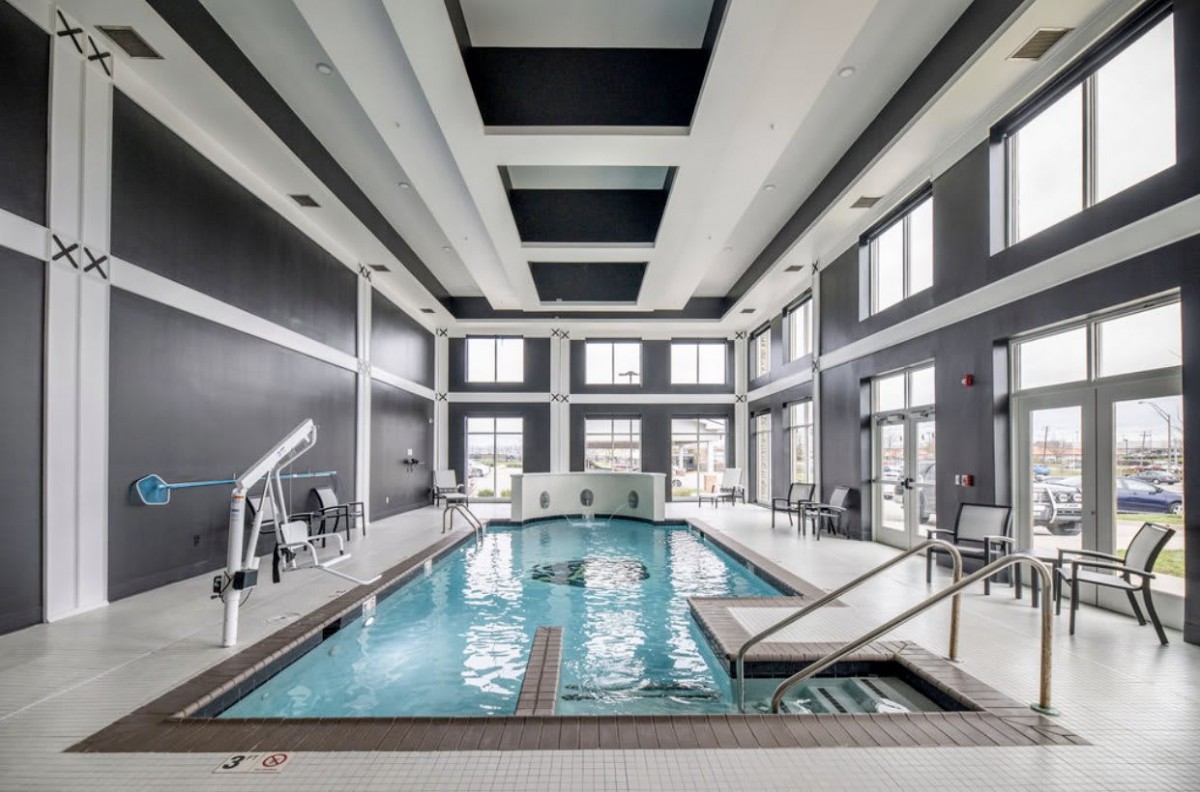 A modern indoor swimming pool with large windows and sleek architectural design.