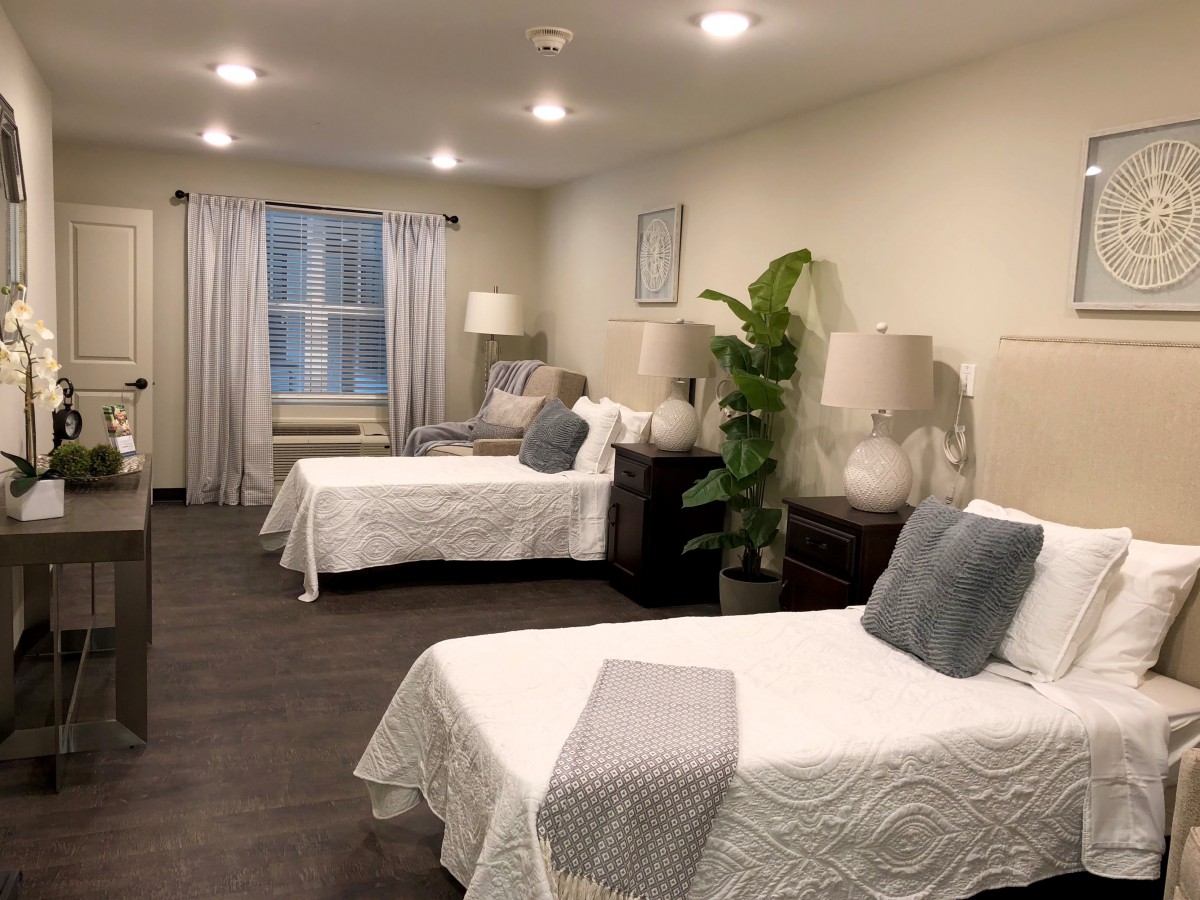 A cozy bedroom with multiple beds, elegant decor, and ambient lighting.