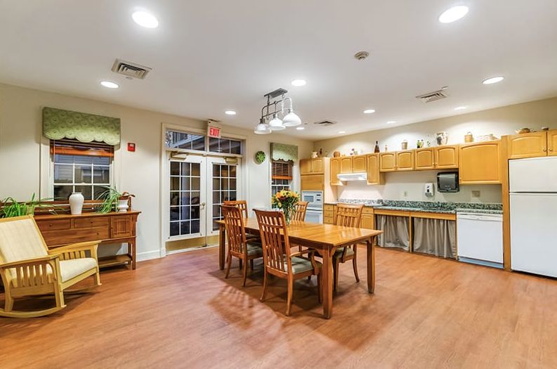A spacious kitchen interior with a wooden dining table and modern amenities.