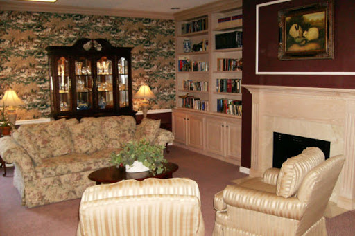 A warm and inviting living room featuring comfortable seating, a fireplace, and a collection of books.