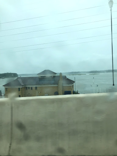 A view of a house by the water on a cloudy, rainy day.