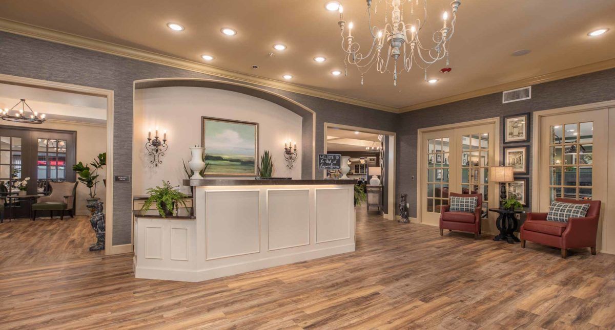 A modern and elegant hotel lobby with a reception desk, chandelier lighting, and stylish interior decor.