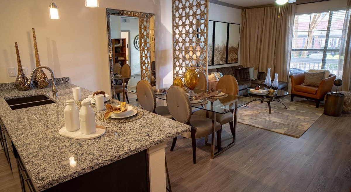 A modern open-concept dining and living area with a decorative screen, stylish furniture, and elegant table settings.