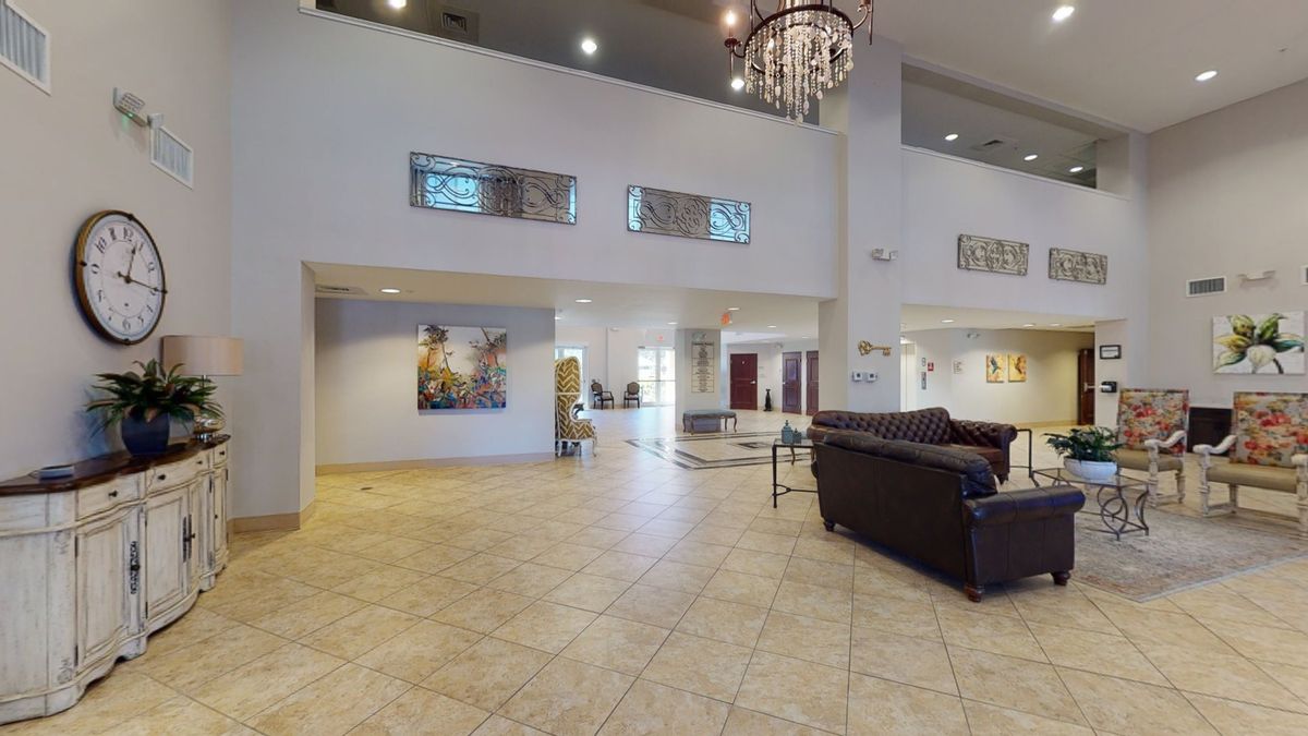 Spacious lobby with modern decor and a large chandelier.