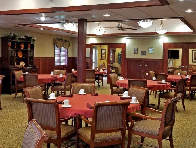 An empty dining room with neatly arranged tables and chairs, featuring a warm and inviting decor.