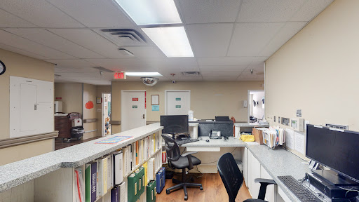 A view of a medical office workspace with computers and organized documents.