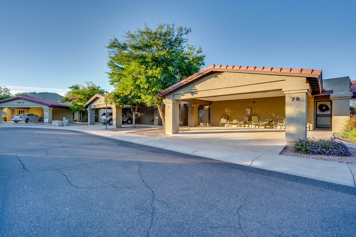 A quiet suburban neighborhood with modern houses and driveways under a clear blue sky.