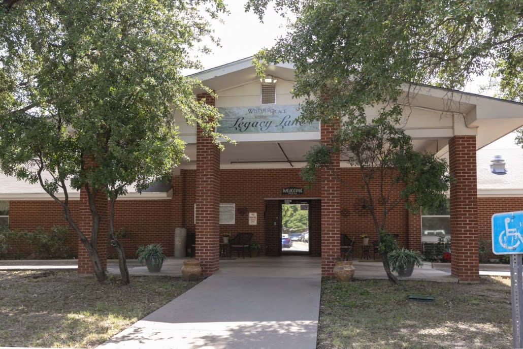 A view of a building entrance surrounded by trees.