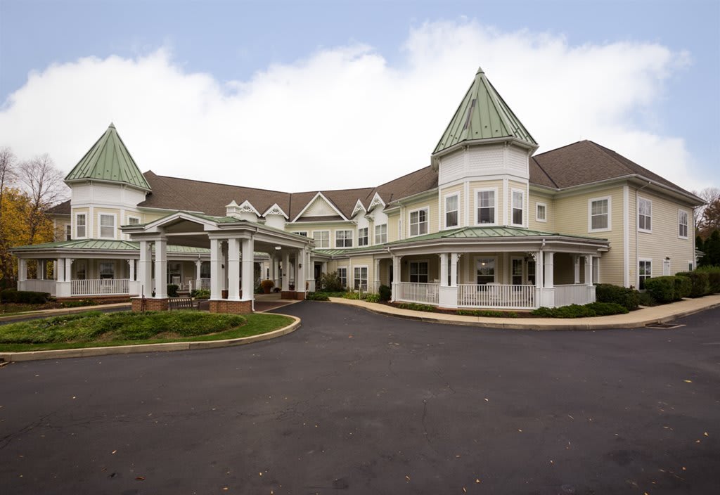 A large, elegant residential building with a covered entrance and driveway.