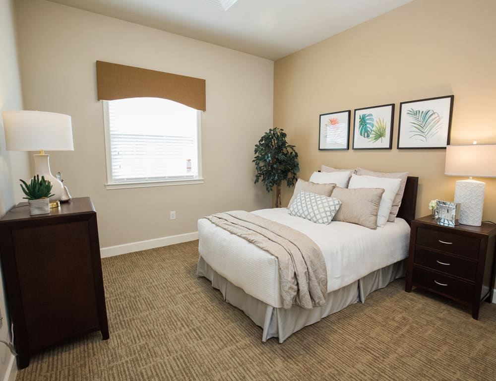 A cozy and minimalist bedroom with a neatly made bed, warm lighting, and simple decor.