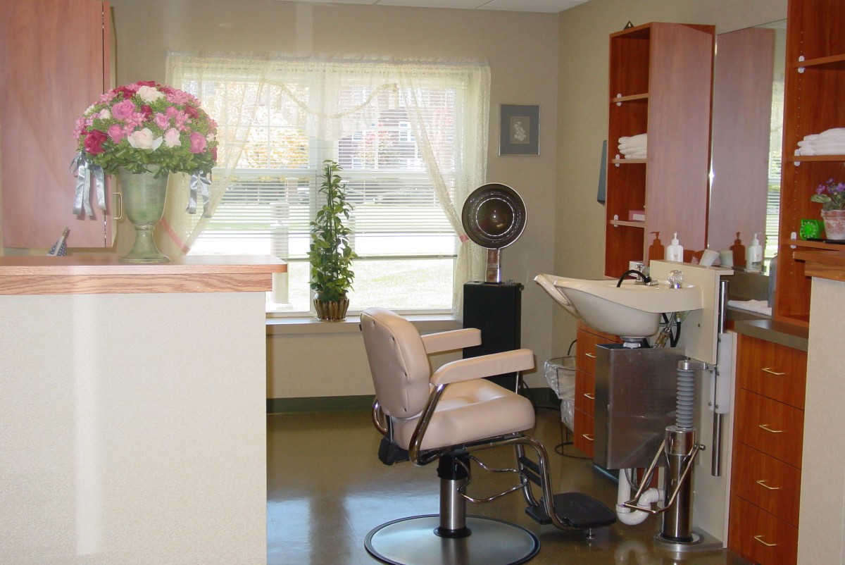 A cozy and well-organized hair salon interior with a styling chair, sink, and various hairdressing equipment.