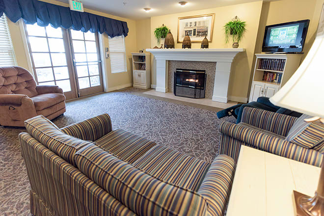 A cozy living room featuring a fireplace, striped sofas, and elegant decor.