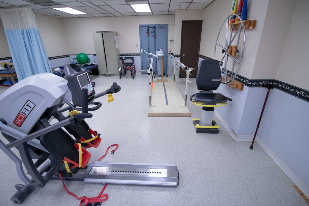 A rehabilitation room equipped with various exercise machines and therapy tools.