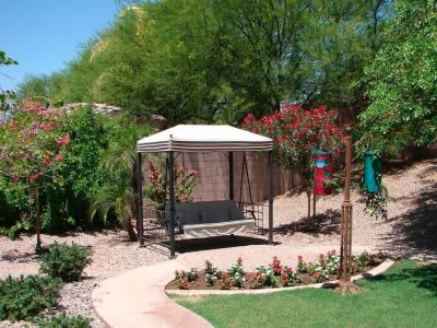 A serene garden with a gazebo surrounded by lush greenery and a winding pathway.