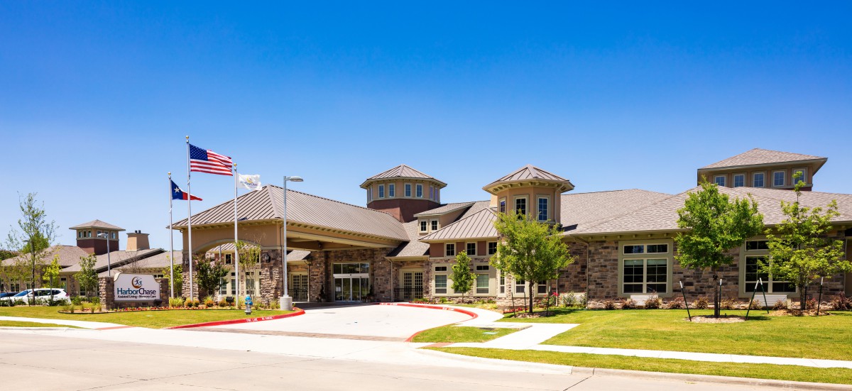 A modern building with a grand entrance and well-maintained landscape.