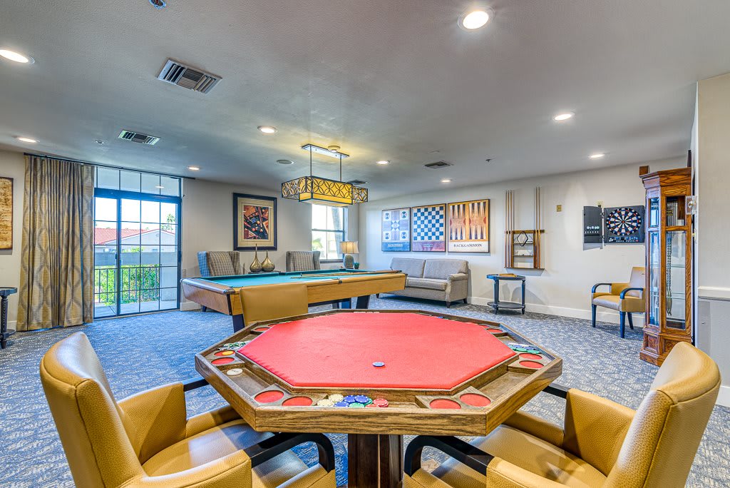 A well-furnished game room featuring a poker table and pool table for entertainment.
