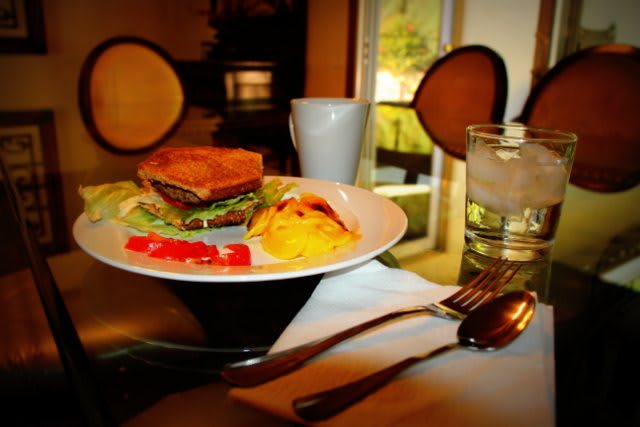 A breakfast plate featuring a sandwich and eggs is set on a dining table.
