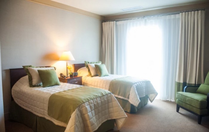 A cozy bedroom with twin beds and soft lighting.