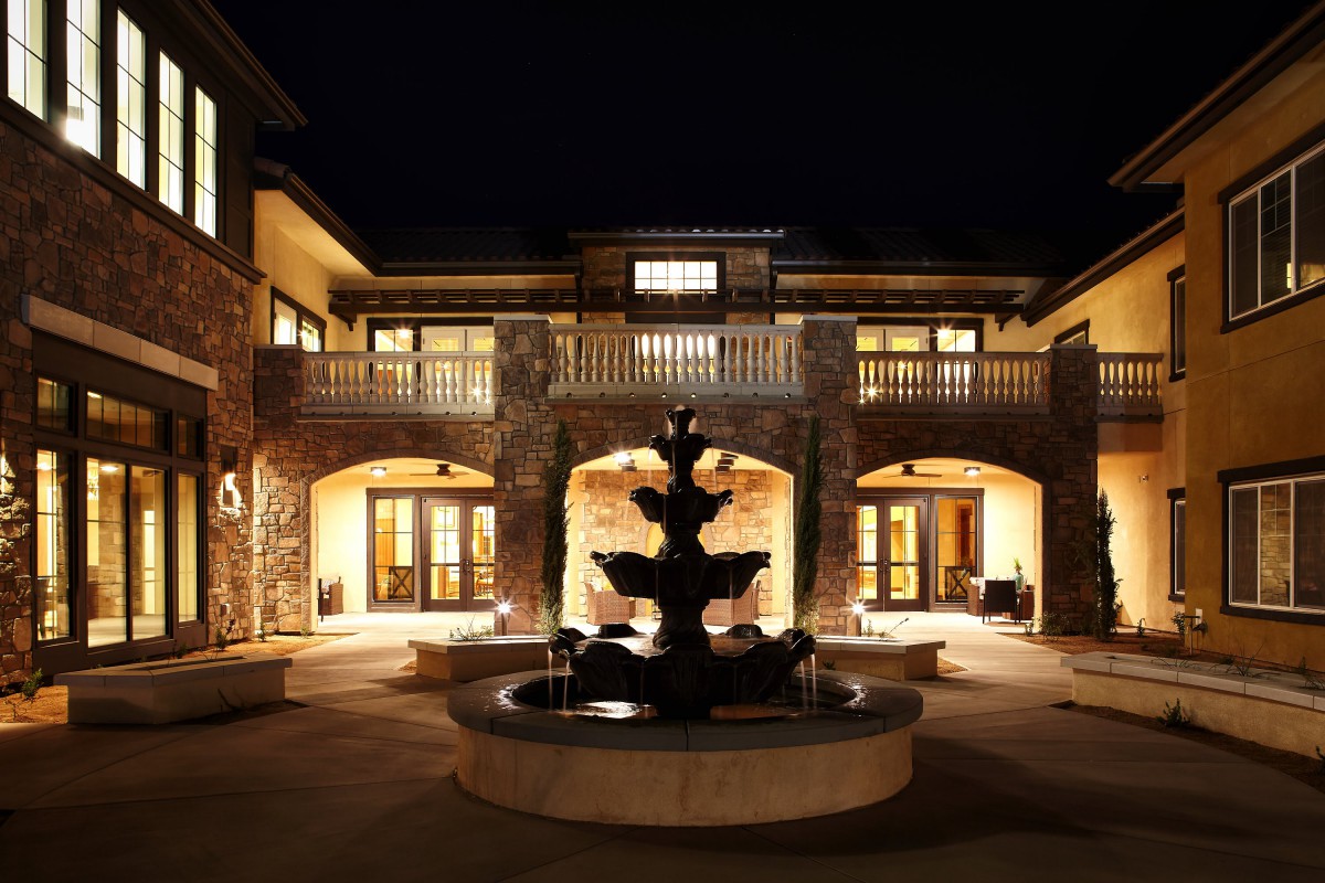 A beautifully lit building with a central fountain at night.