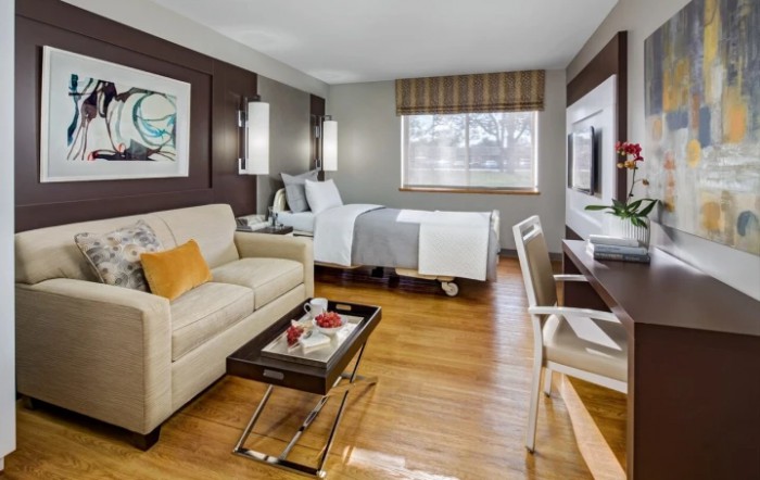 A modern hotel room with a cozy bed, comfortable sofa, and stylish decor.