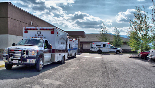 Ambulances parked outside a healthcare facility, ready to respond to emergencies.