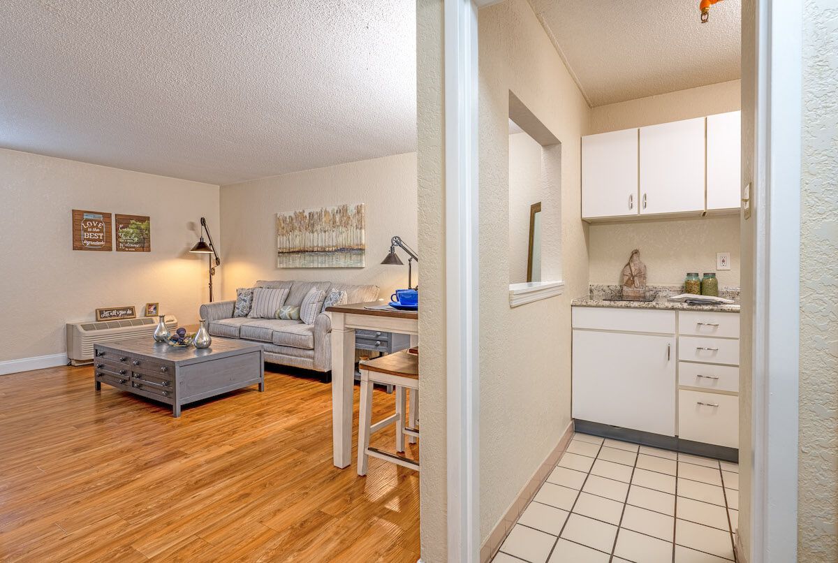 A view of a modern apartment showcasing the cozy living room and compact kitchen.