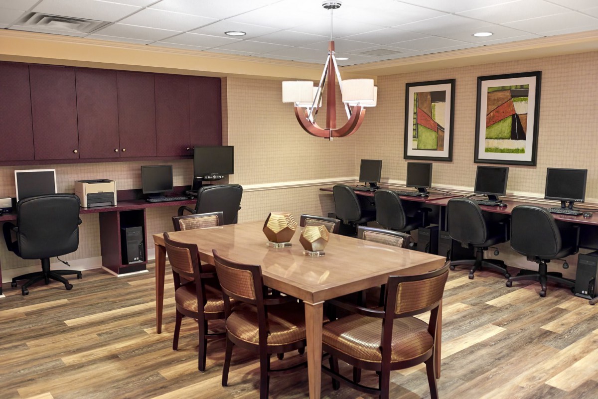 Modern office conference room with computers and a central table.