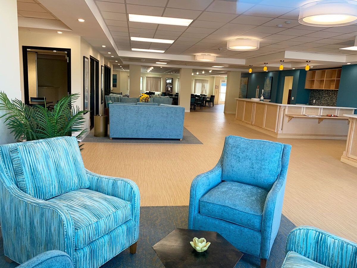 A modern lobby with comfortable blue seating and a reception area.