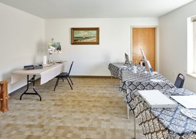 A minimalist office space with tables, chairs, and computer screens arranged neatly.