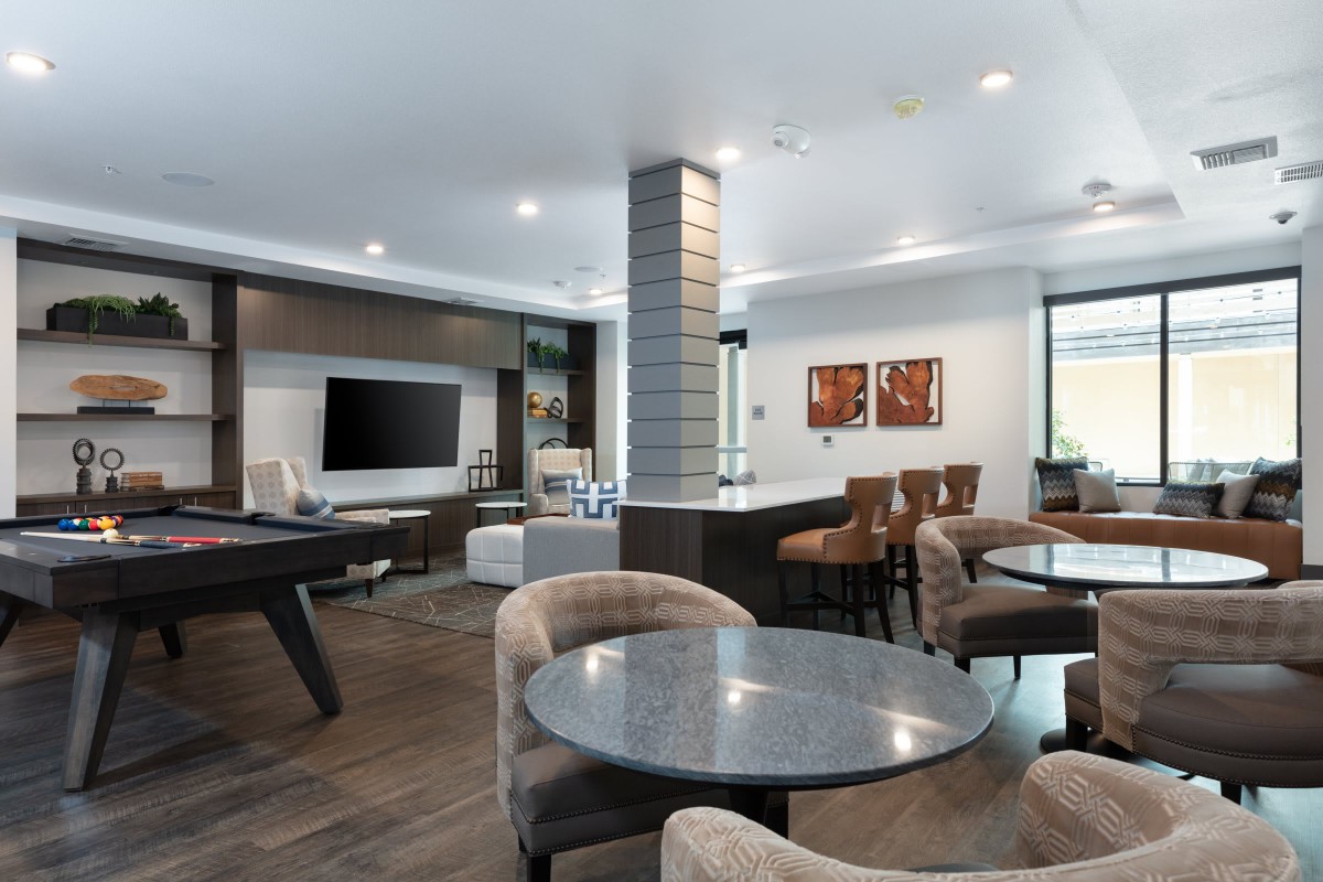 A modern living room with stylish furniture and a large television.