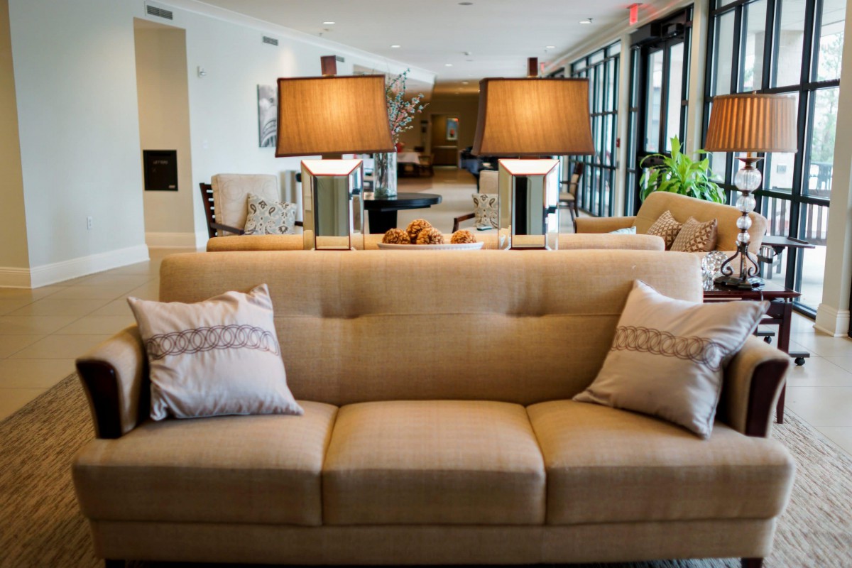 A well-decorated living room with a beige sofa and two stylish lamps.