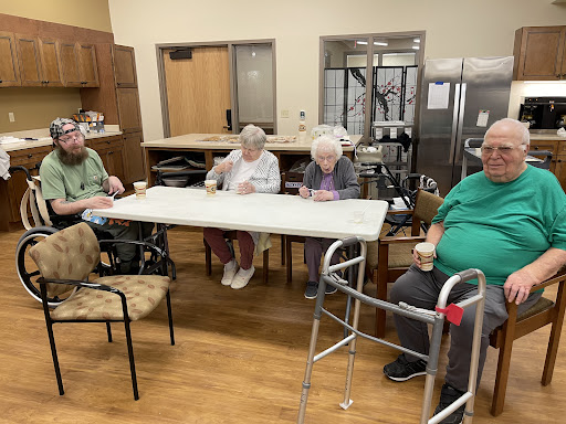 Residents enjoying snacks together in a care facility.