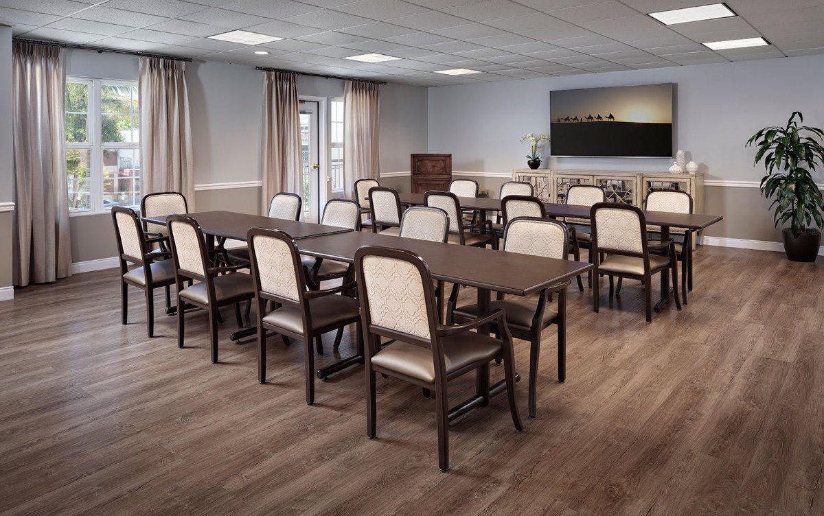 A conference room with multiple tables and chairs arranged for a meeting.