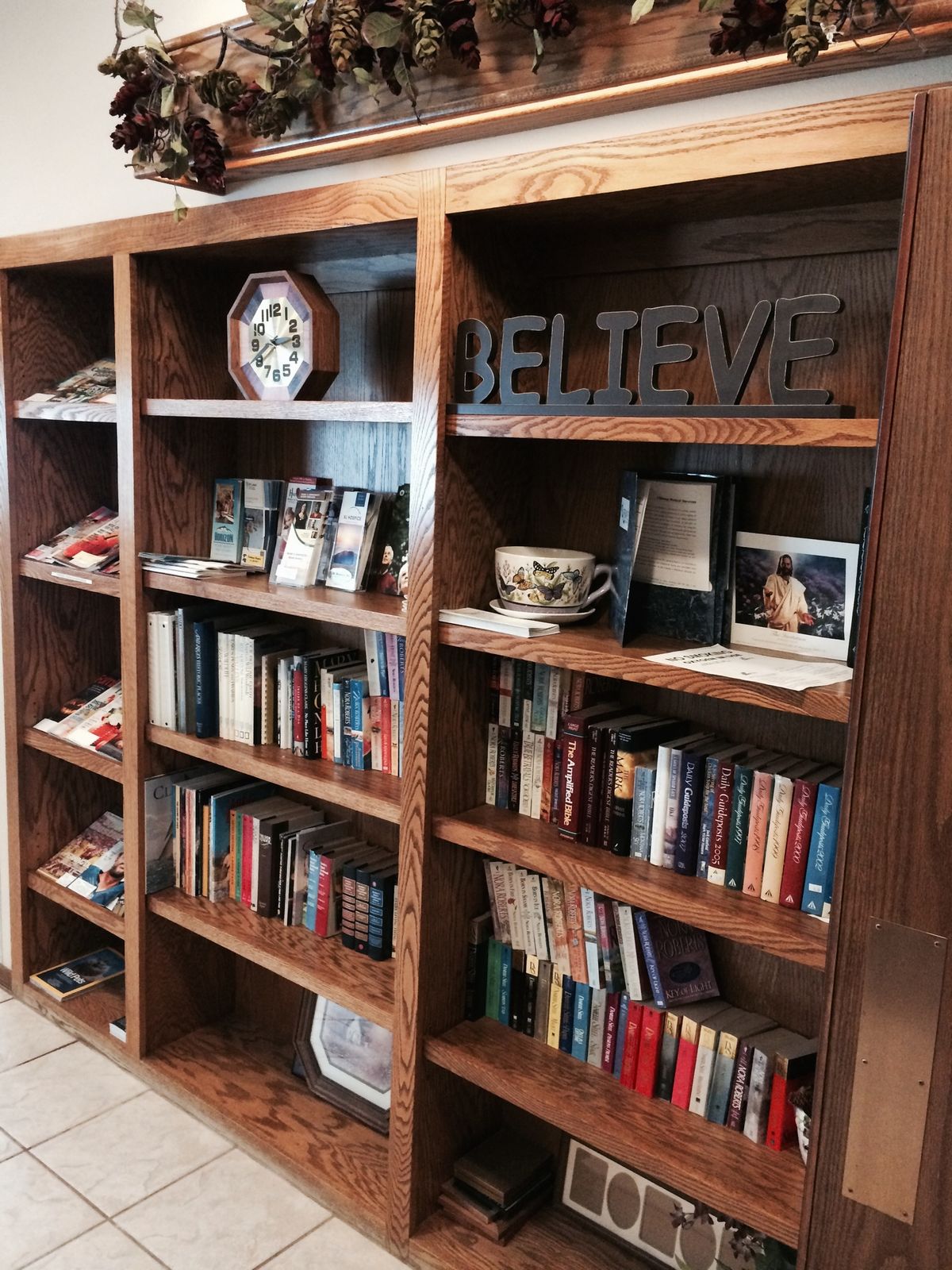 A neatly arranged wooden bookshelf filled with books and decorative items.