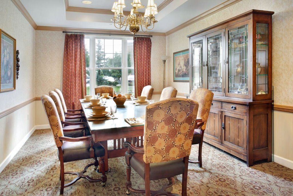 A stylish dining room featuring a wooden table and chairs, accented with a chandelier and elegant decor.