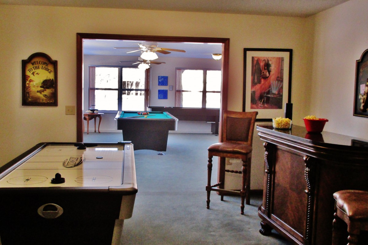 A spacious game room featuring a pool table and bar area, perfect for leisure activities.