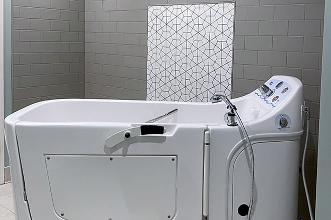 A modern bathtub in a stylish bathroom with geometric tile design.