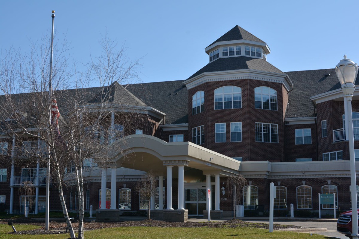 A large multi-story brick building with a prominent entrance and unique architectural features.
