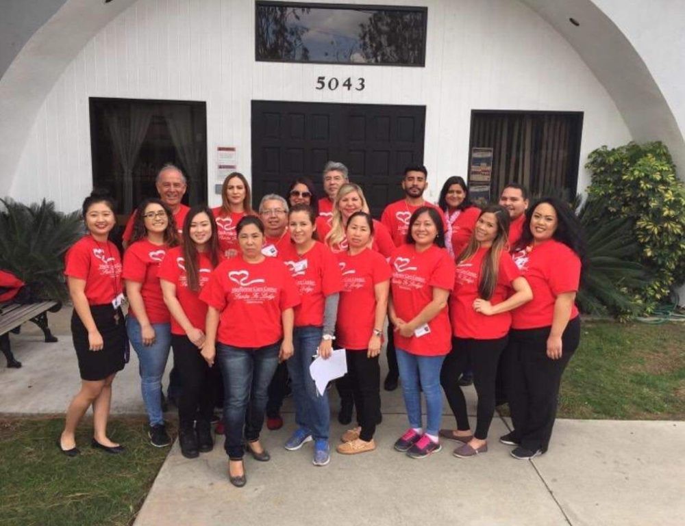 A group of people wearing red shirts standing in front of a building.