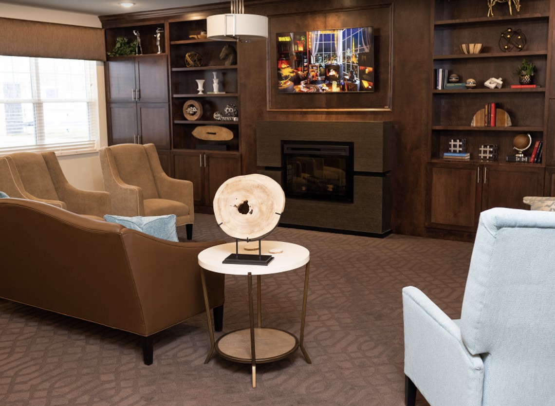 A cozy living room featuring a modern fireplace, stylish furniture, and decorative elements.
