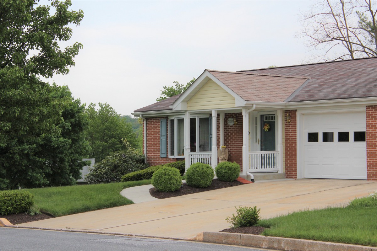A suburban brick house with a well-maintained lawn and driveway.