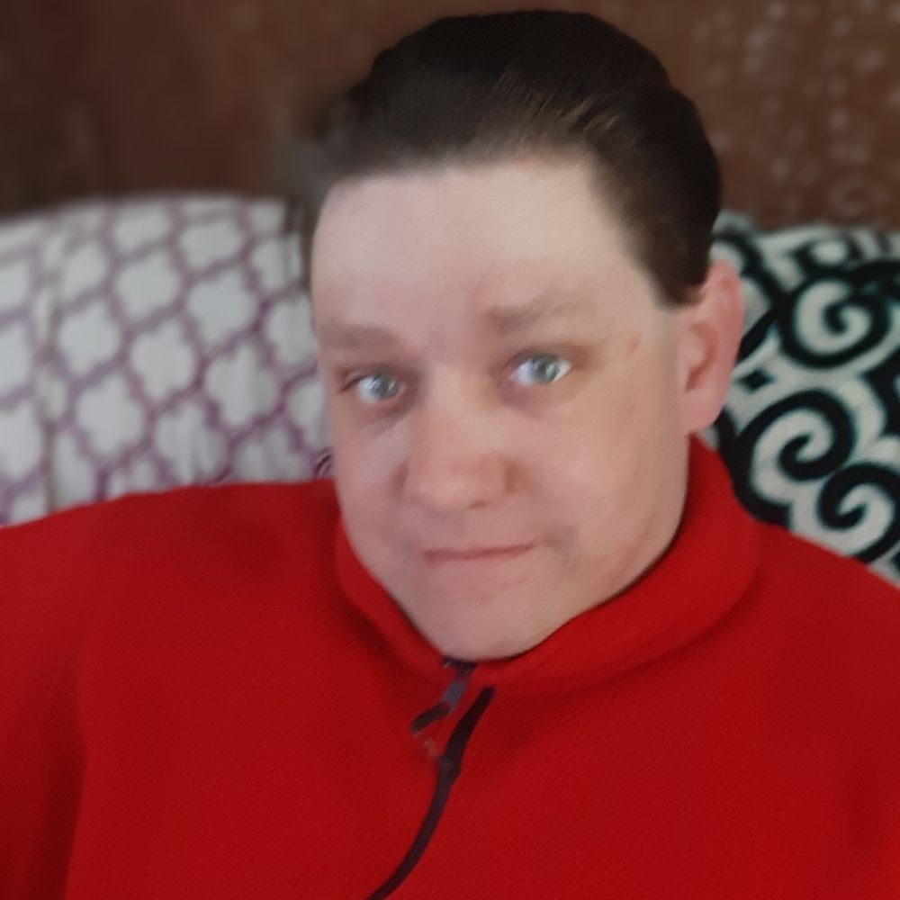 Person wearing a red jacket sitting on a couch.